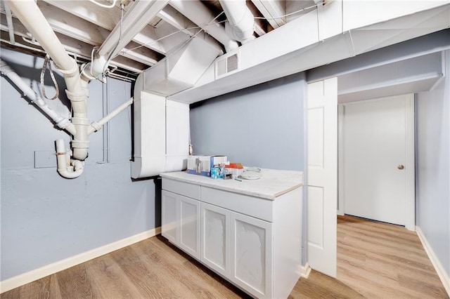 basement with light hardwood / wood-style flooring