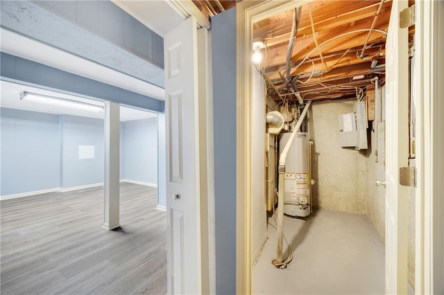 basement with electric panel, hardwood / wood-style flooring, and gas water heater