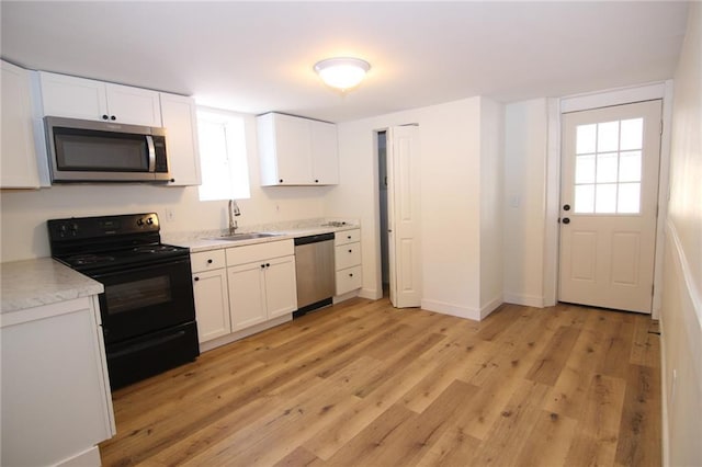 kitchen featuring white cabinetry, sink, light hardwood / wood-style flooring, and stainless steel appliances