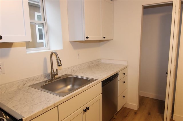 kitchen featuring white cabinetry, sink, stainless steel dishwasher, and light wood-type flooring