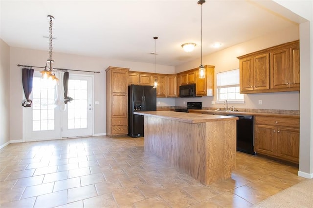 kitchen with a kitchen island, sink, black appliances, light tile patterned flooring, and decorative light fixtures