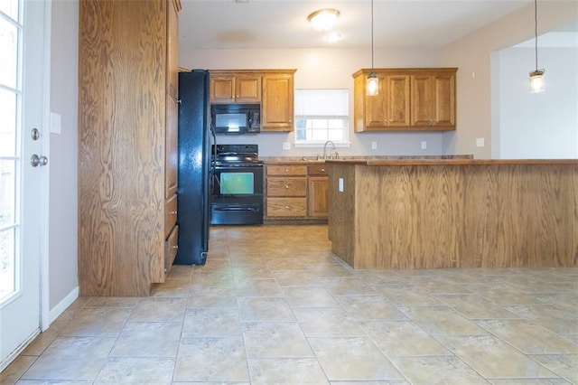 kitchen featuring sink, black appliances, and pendant lighting