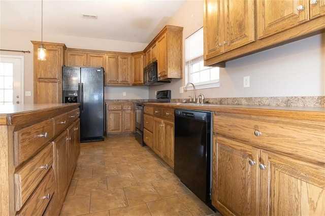 kitchen with decorative light fixtures, black appliances, and sink