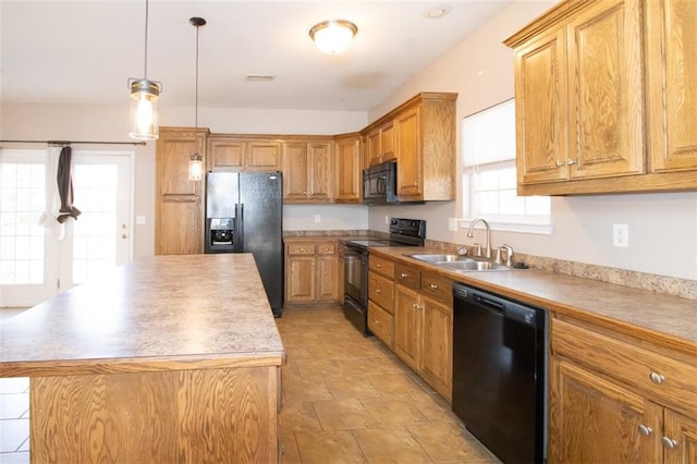 kitchen with sink, black appliances, a center island, and pendant lighting