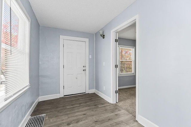 446 Montgall Ave, Kansas City, MO 64124 - entrance foyer with wood finished floors, baseboards, and a textured ceiling