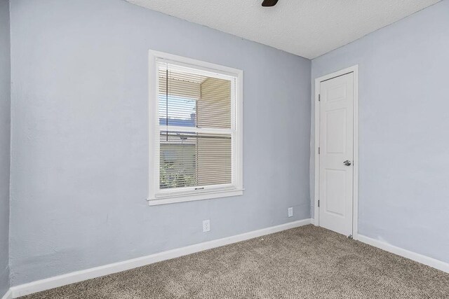 446 Montgall Ave, Kansas City, MO 64124 - unfurnished room with carpet, baseboards, and a textured ceiling