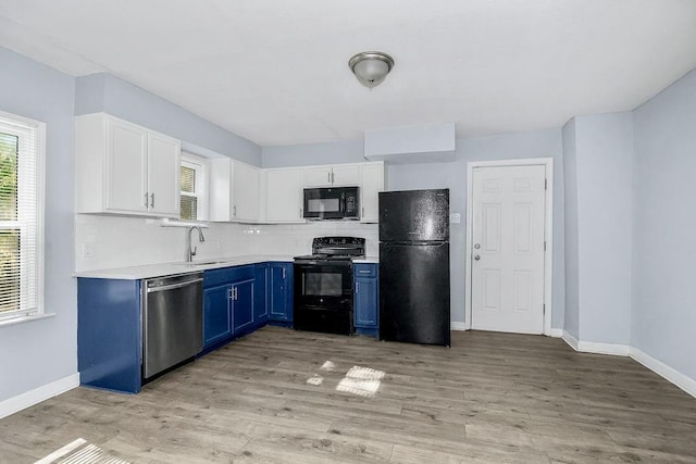 446 Montgall Ave, Kansas City, MO 64124 - kitchen featuring black appliances, blue cabinetry, light countertops, and healthy amount of natural light