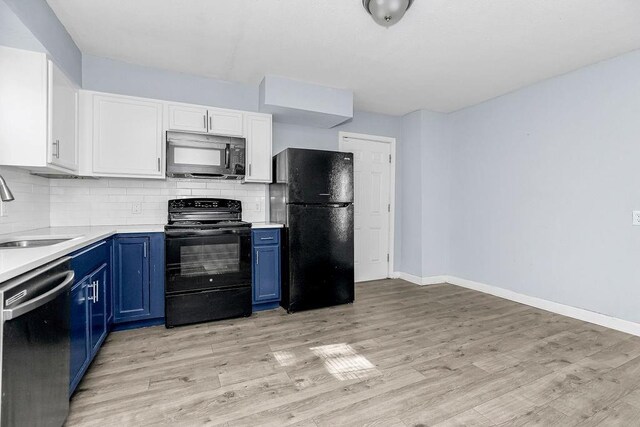 446 Montgall Ave, Kansas City, MO 64124 - kitchen with black appliances, blue cabinets, a sink, and light countertops