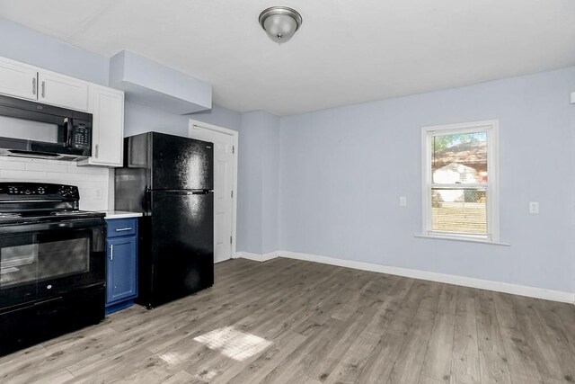 446 Montgall Ave, Kansas City, MO 64124 - kitchen with black appliances, light wood finished floors, baseboards, and blue cabinets
