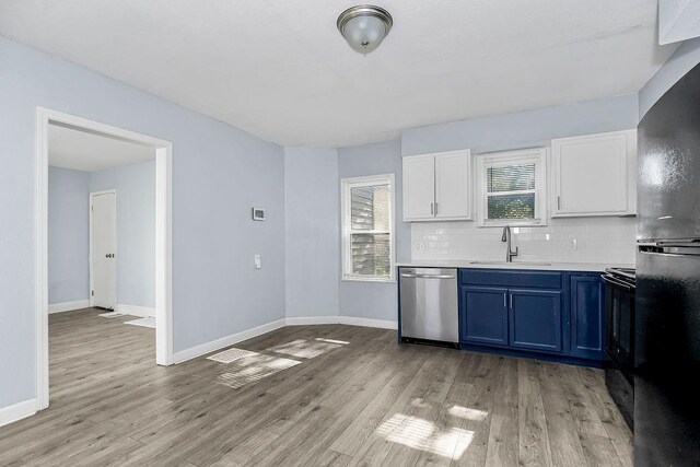 446 Montgall Ave, Kansas City, MO 64124 - kitchen featuring black appliances, blue cabinetry, a sink, light countertops, and backsplash