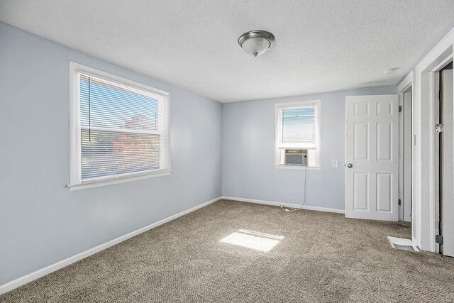 446 Montgall Ave, Kansas City, MO 64124 - unfurnished bedroom featuring carpet floors, a textured ceiling, baseboards, and cooling unit