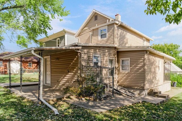 446 Montgall Ave, Kansas City, MO 64124 - rear view of property with a chimney, a gate, and a patio