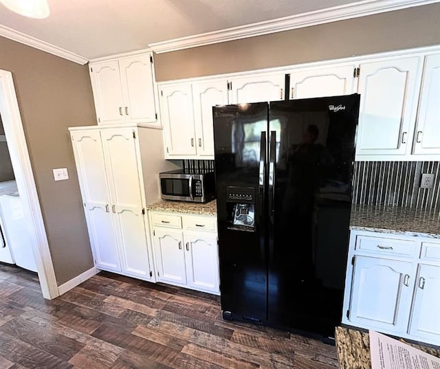 kitchen with white cabinets, decorative backsplash, and black fridge