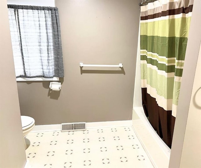 bathroom featuring toilet and shower / bath combination with curtain