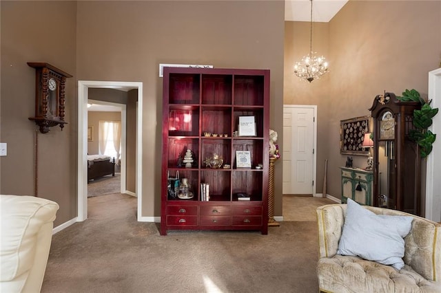 sitting room featuring carpet floors, a towering ceiling, and a chandelier