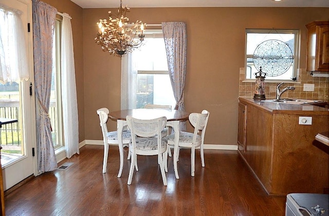 dining room featuring a notable chandelier, dark hardwood / wood-style flooring, and sink