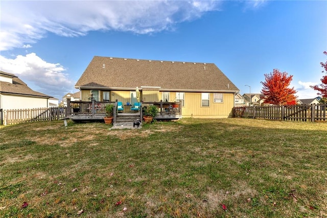 rear view of house with a yard and a wooden deck