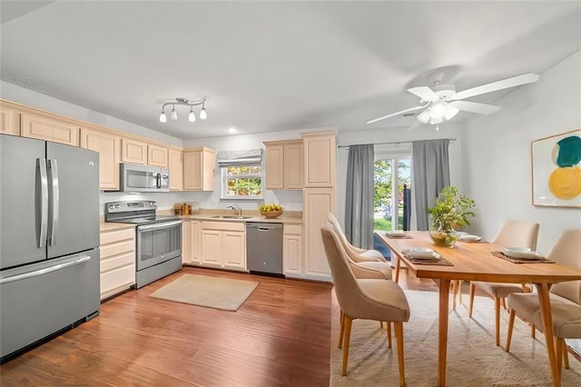 kitchen with ceiling fan, sink, light hardwood / wood-style floors, cream cabinetry, and appliances with stainless steel finishes