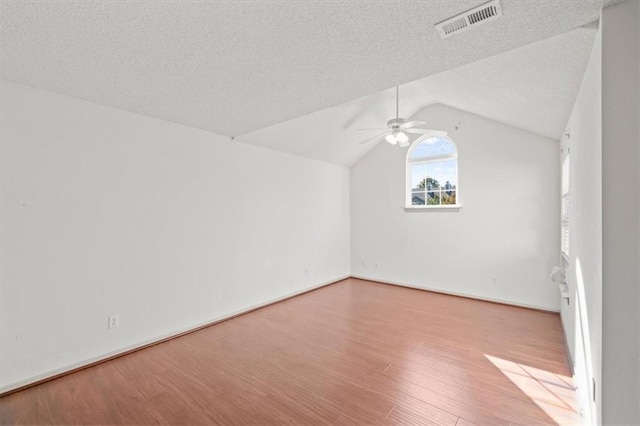 bonus room with a textured ceiling, light wood-type flooring, vaulted ceiling, and ceiling fan