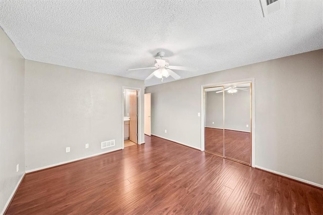 unfurnished room with a textured ceiling and hardwood / wood-style flooring