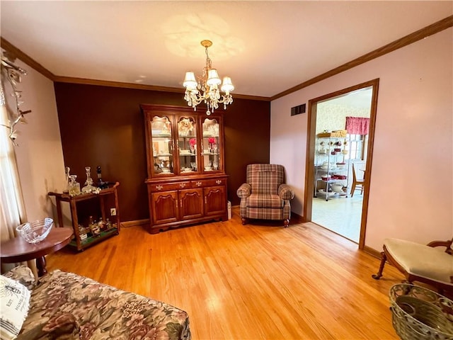 sitting room featuring crown molding, a chandelier, and light wood-type flooring