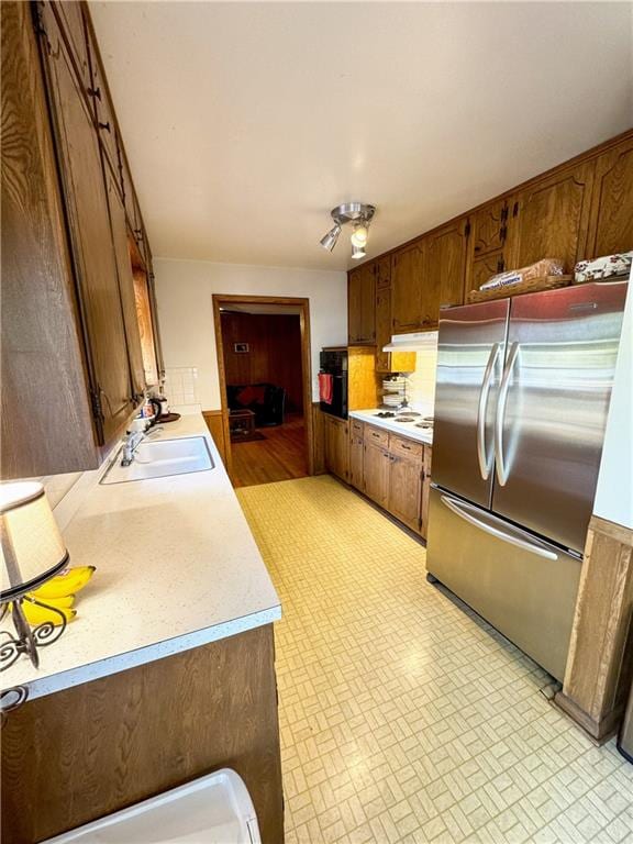 kitchen with stainless steel refrigerator, sink, and oven