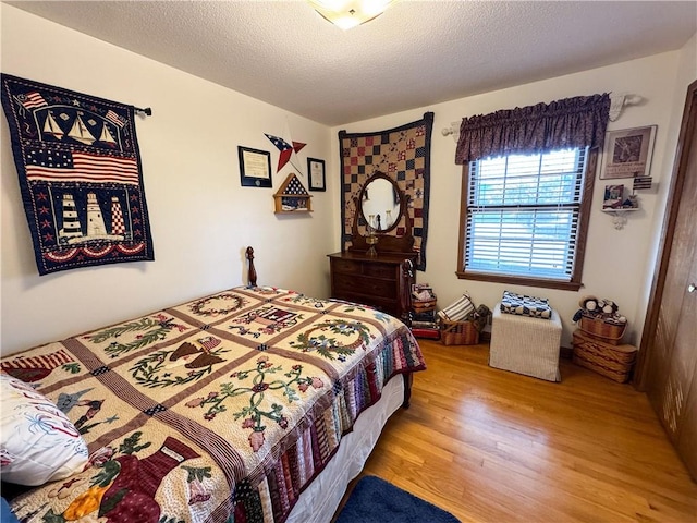 bedroom featuring a textured ceiling and light hardwood / wood-style floors