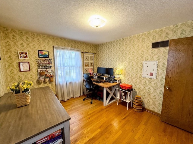 office space with light hardwood / wood-style floors and a textured ceiling