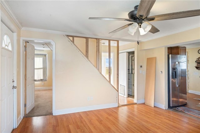 unfurnished room with ornamental molding, light wood-type flooring, and ceiling fan