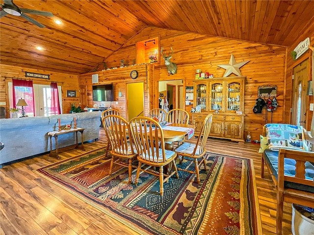 dining space featuring wood walls, wood-type flooring, wood ceiling, and vaulted ceiling