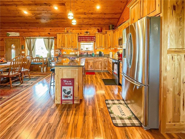 kitchen featuring light hardwood / wood-style flooring, a kitchen island, lofted ceiling, and appliances with stainless steel finishes