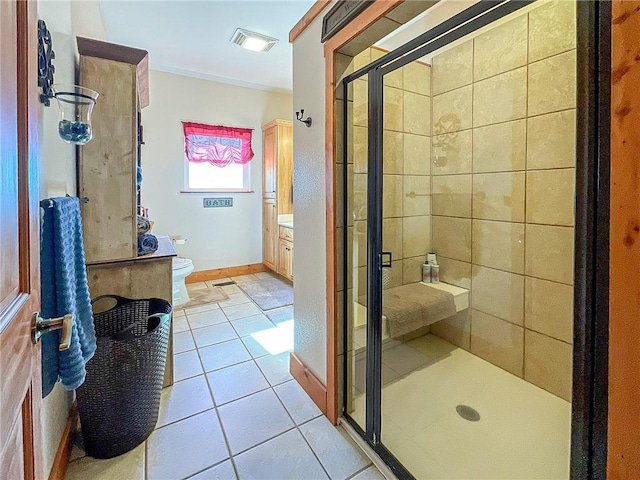 bathroom featuring vanity, tile patterned floors, crown molding, toilet, and walk in shower