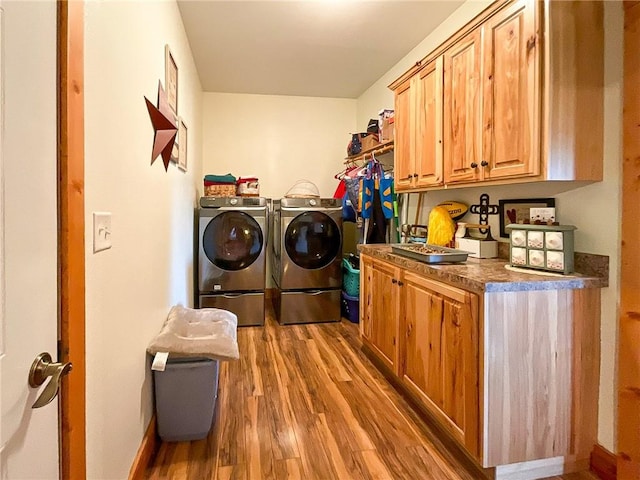 washroom featuring washer and dryer, cabinets, and hardwood / wood-style flooring