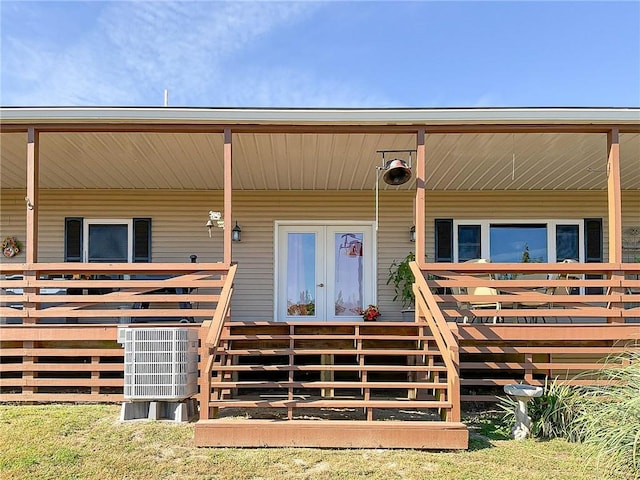 view of exterior entry featuring french doors and central AC