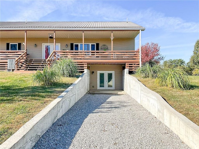 back of house with a yard, a wooden deck, and french doors