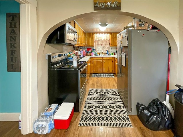 kitchen with light hardwood / wood-style floors, sink, and appliances with stainless steel finishes