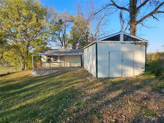 view of outbuilding with a lawn and a porch