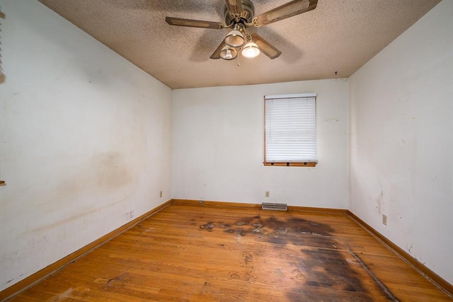 unfurnished room featuring ceiling fan, wood-type flooring, and a textured ceiling