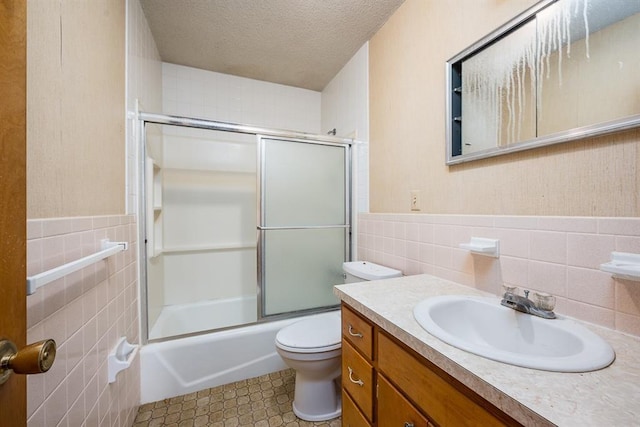 full bathroom with a textured ceiling, toilet, tile walls, and enclosed tub / shower combo