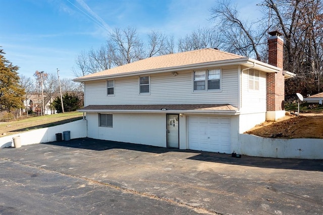 rear view of property with a garage