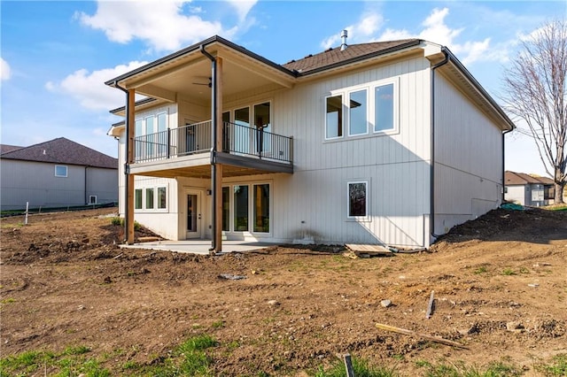 rear view of house featuring a balcony and a patio