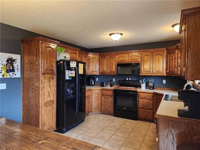 kitchen featuring light tile patterned floors, black appliances, and a textured ceiling