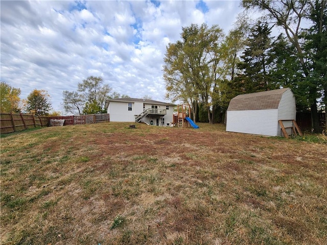 view of yard with a storage shed and a playground