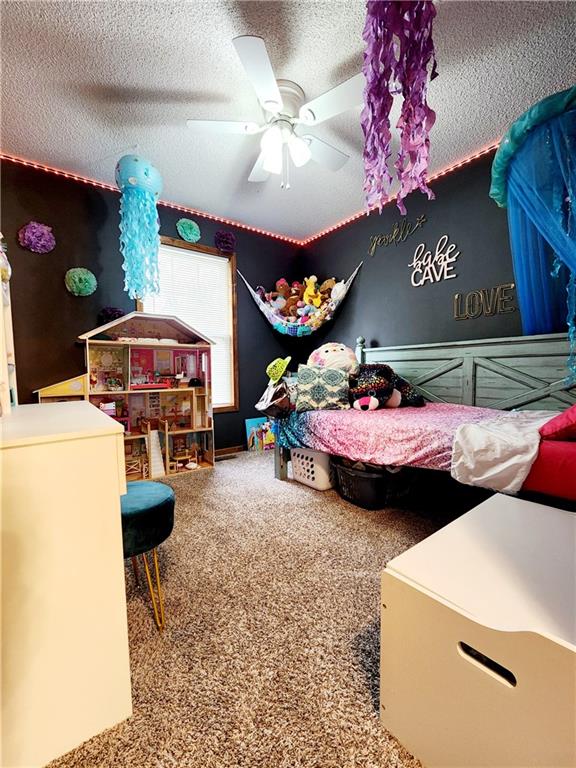 bedroom with a textured ceiling and ceiling fan