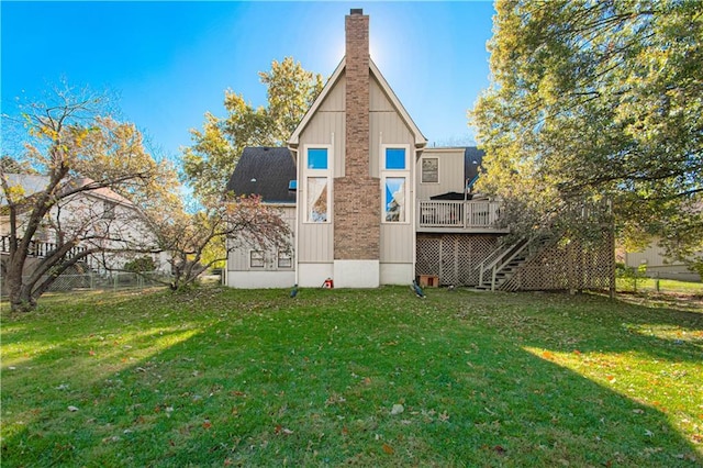 back of property with a wooden deck and a yard