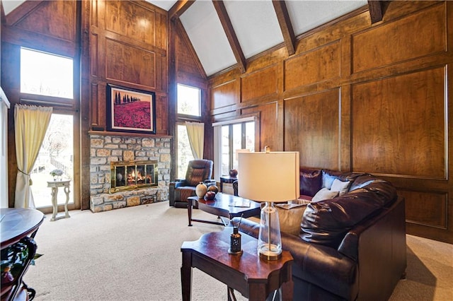 living room featuring high vaulted ceiling, wooden walls, carpet flooring, a fireplace, and beamed ceiling