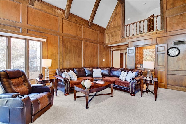 carpeted living room featuring beam ceiling, high vaulted ceiling, and wooden walls