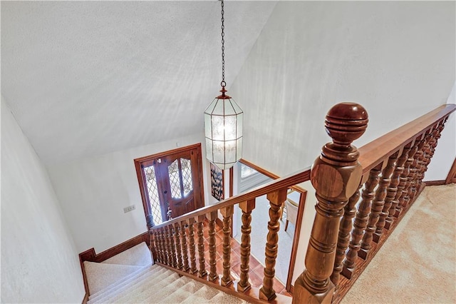 staircase with carpet and lofted ceiling