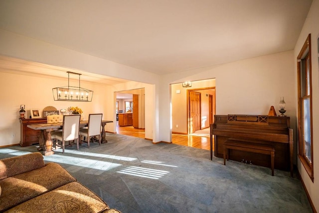 carpeted living room with a notable chandelier