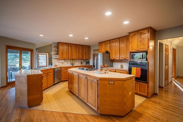 kitchen featuring light hardwood / wood-style floors, stainless steel appliances, tasteful backsplash, and a center island